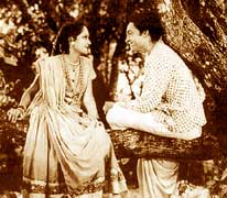 A man and woman smile at each other in an old film
