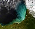 Yucatán Yarımadası'nın Meksika Körfezi açıkları. Renk patlaması sığ sulara denk gelmekte ve taba, yeşil, mavi ve beyaz renkli girdaplar ise hem kara hem de deniz tabanından kaynaklanan çökelmeleri göstermektedir