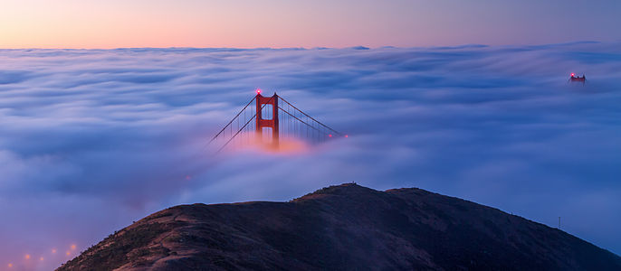A view of the Golden Gate Bridge from the Marin Headlands on a foggy morning at sunrise