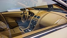 The interior of a luxury car. The bronze upholstery is the most prominent colour, but there are hints of brown too.