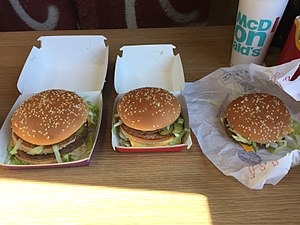 A Grand Big Mac (left) and Mac Jr. (right) alongside a regular Big Mac (center), released for a limited time in the UK as part of the 50th anniversary of the burger