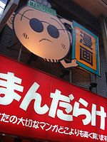 Signage for Mandarake Umeda in Osaka, depicting a cartoon image of Masuzo Furukawa.