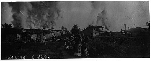Burning buildings, with residents watching