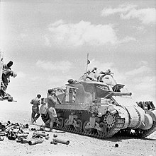 photographie en noir et blanc montrant des soldats charger des obus dans un char