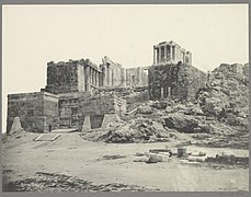 Black-and-white photograph of the gate, from a distance, showing the Temple of Athena Nike above