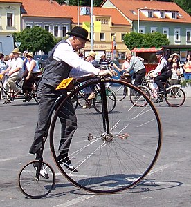 A rider stands on the mounting peg to lift his other leg to a pedal