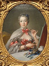Oval portrait of an elegant woman in a low-bosomed dess, wearing a cloak tied at the neck with a ribbon. She is holding a small flower in her left hand.