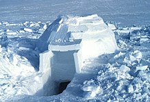 A nearly complete, medium-sized igloo, with excavation under the door and the exterior unfinished