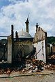 Rrënojat e Çarshisë së Madhe në Gjakovë, e rrënuar nga ushtria serbe 1999, me Xhaminë e Hadumit në sfond.