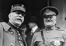Photographie noir et blanc de deux hommes en habit militaire souriant.