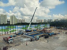 View of the construction site with construction equipment and cranes around an excavated hole