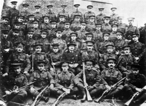 Photographie de soldats en uniformes britanniques assis et debout sur six rangées