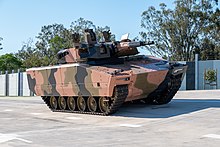Colour photo of a tracked military vehicle with a gun turret
