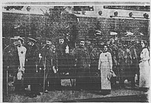 B&W photo of men in uniform standing around