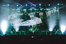 Gojira onstage, performing in front of a large screen