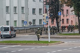 Running internal troopers in Minsk. Note the van with darkened glasses and without the registration plate: such vans are reported to be used by the government forces to bring reinforcements and detain people[316][317]