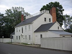 Back side of a two-story, white, clapboard house