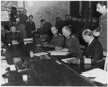 Generálplukovník Alfred Jodl, jako vyslanec Karla Dönitze, při podpisu bezpodmínečné kapitulace nacistického Německa 7. května 1945 v Remeši
