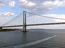 View of the Verrazano-Narrows Bridge looking south from Upper New York Bay. The neighborhood of Coney Island in Brooklyn can be seen in the distance.