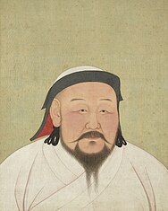 Portrait of a bearded man wearing white robes and a white and black headscarf.