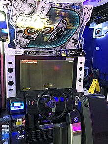 An arcade cabinet with a steering wheel and a seat