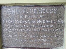 Grey plaque describing construction of the club house