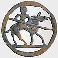 Fíbula germana del siglo VI que representa un guerrero a caballo con lanza.