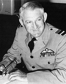 Half-length portrait of Ellis Wackett in military uniform, with pilotʼs wings on left breast pocket and pipe in left hand