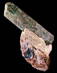 Fluorapatit: Kristal seperti prisma panjang, tanpa kilauan, pada sudut keluar dari batu seperti agregat