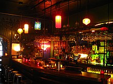 Photograph of a dimly lit bar counter with lights hanging from above