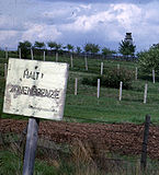 The "second-generation" fences in 1962, with derelict barbed wire in the foreground, a control strip, two rows of barbed wire further back and a watchtower at the rear