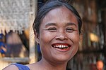 A Lao woman with the characteristic red-stained teeth and gums from chewing betel nut