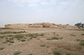 Photo of a mound of ruins in a barren field