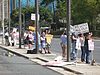 A group of people holding placards in the middle of the road