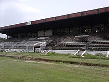 Large, disused grandstand with the letters RCTC on the roof