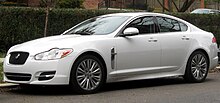 Colour photo of a white Jaguar XF pictured parked on a suburban roadside