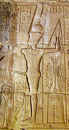 Relief of a man with an erection, wearing a headdress of two feathers and a disk