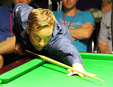 Ali Carter leaning ower a table while lining up a shot