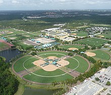 Aerial view of a several sports fields for baseball and soccer with a central arena and several tents