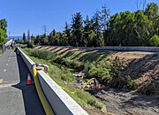 In July, 2019, the entire flow of the creek is diverted through a hose for creekbed weed cleanout by the Google campus.