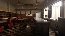 Photograph of an empty restaurant interior, with booths, a lunch counter, and shelves on walls