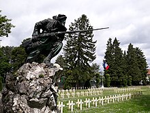 Monument représentant un fantassin français, baïonnette au canon. La statue en bronze est placée au sommet d'un rocher (photographie moderne).