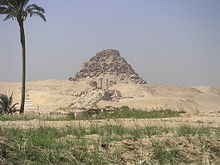 Photograph of the eroded remains of a pyramid with the remaining complex laid out before it