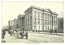 A depiction of the Courthouse showing carts on the street and people walking on the sidewalks