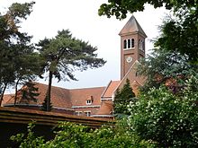 Abbey building with a bell tower with some trees in front