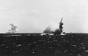 El O´Brien siendo impactado por un torpedo, al fondo el USS Wasp envuelto en incendios.
