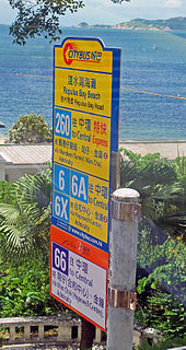 A sign, seen through a vehicle, with large numbers and text in Chinese and English. The upper portion is yellow; a small section at the bottom is in orange