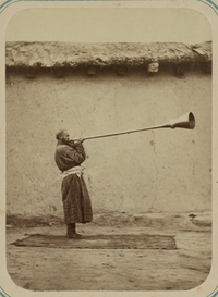 man playing a karnay trumpet