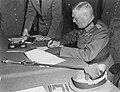 Image 20 German Instrument of Surrender Photograph credit: Lt. Moore; restored by Adam Cuerden The German Instrument of Surrender was the legal document that effected the termination of the Nazi regime and ended World War II in Europe. A July 1944 draft version had also included the surrender of the German government, but this was changed due to concern that there might be no functional German government that could surrender; instead, the document stated that it could be "superseded by any general instrument of surrender imposed by, or on behalf of the United Nations", which was done the next month. This photograph shows Field Marshal Wilhelm Keitel signing the German Instrument of Surrender in Berlin. The first surrender document was signed on 7 May 1945 in Reims by General Alfred Jodl, but this version was not recognized by the Soviet High Command and a revised version was required. Prepared in three languages on 8 May, it was not ready for signing in Berlin until after midnight; consequently, the physical signing was delayed until nearly 1:00 a.m. on 9 May, and backdated to 8 May to be consistent with the Reims agreement and public announcements of the surrender already made by Western leaders.
