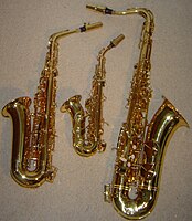 From left to right, an E♭ alto saxophone, a curved B♭ soprano saxophone, and a B♭ tenor saxophone